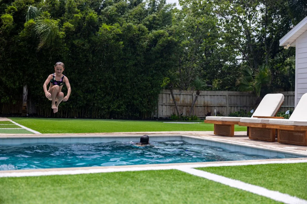 Family Tides backyard pool with a cannonball mid-air