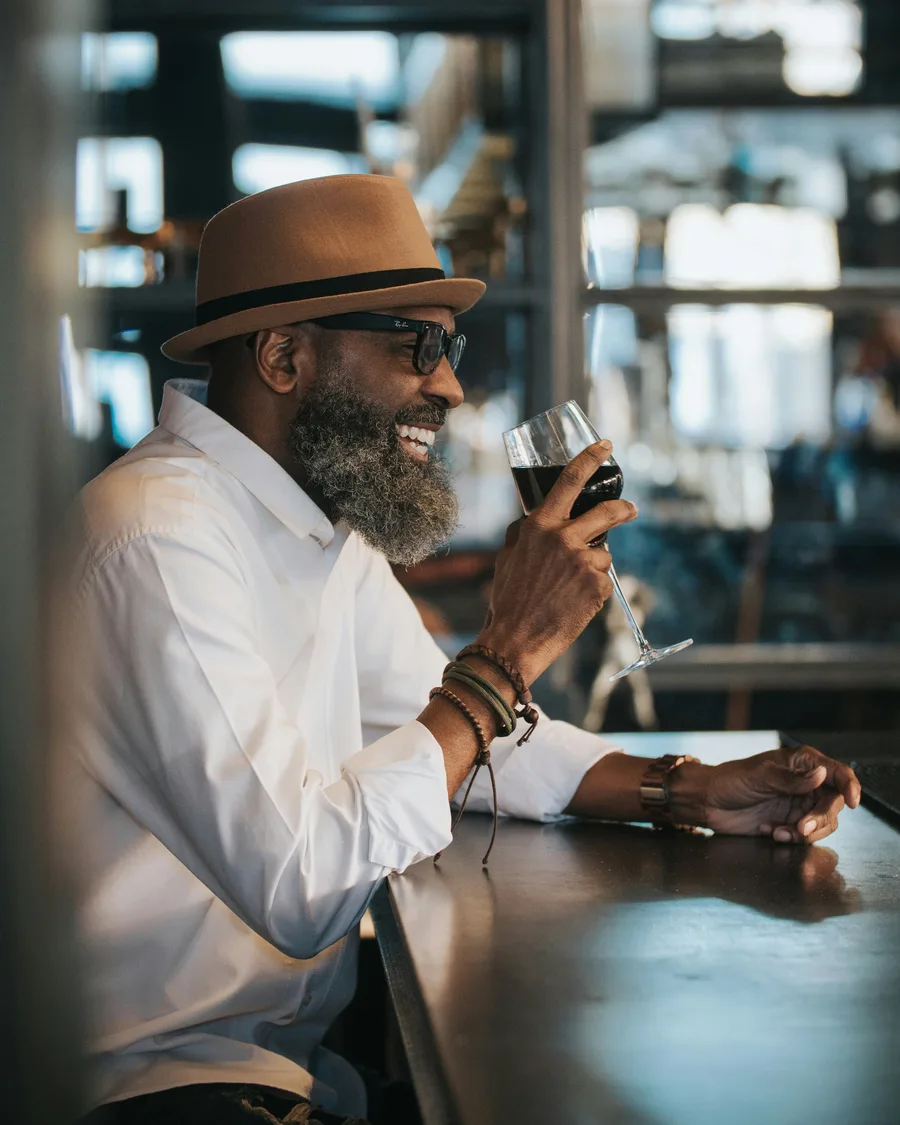 Man enjoying a glass of red wine at a tasting bar